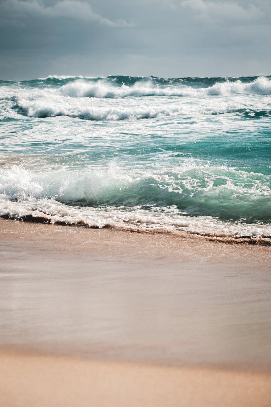 foamy sea waving on sandy beach